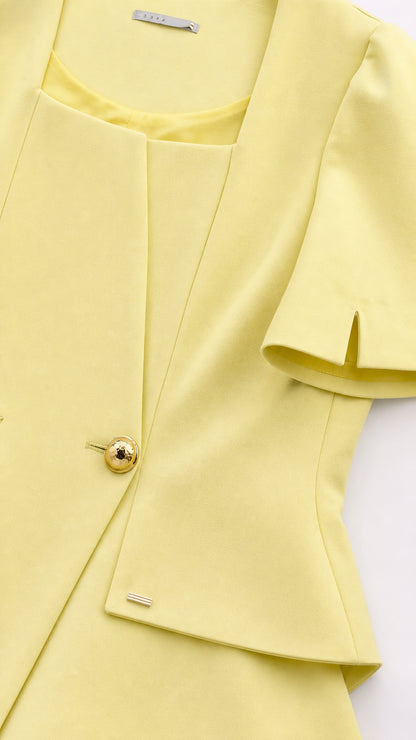 Close-up detail of yellow jacket neckline and gold buttons