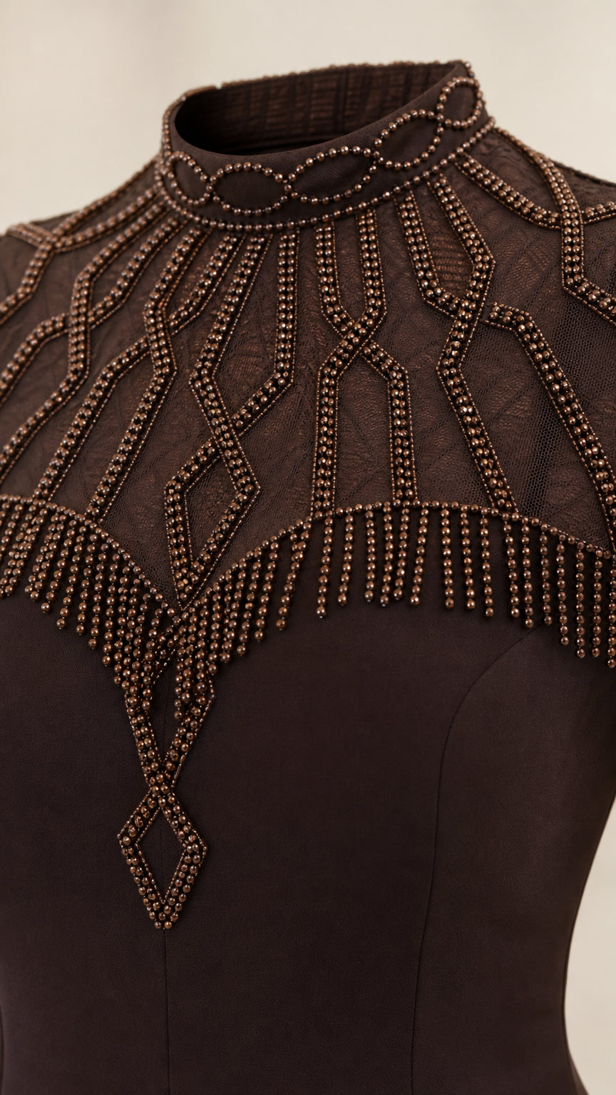 Close-up detail of geometric beadwork on sheer mesh high collar neckline