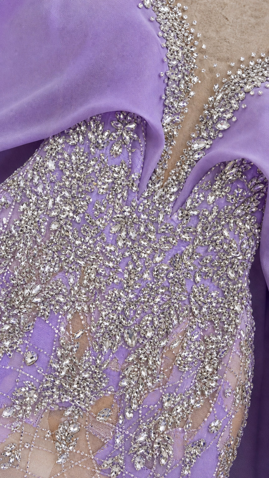 Close-up detail of silver crystal and sequin beadwork on purple mesh lace