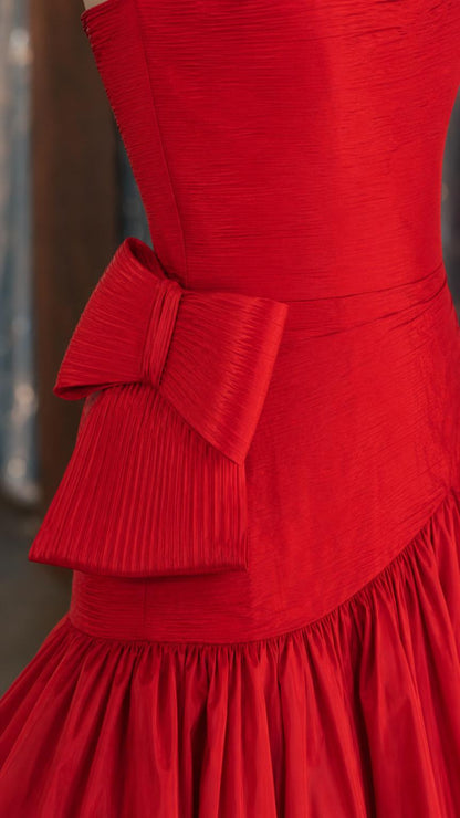 Close-up detail of structured bodice and side bow on red gown