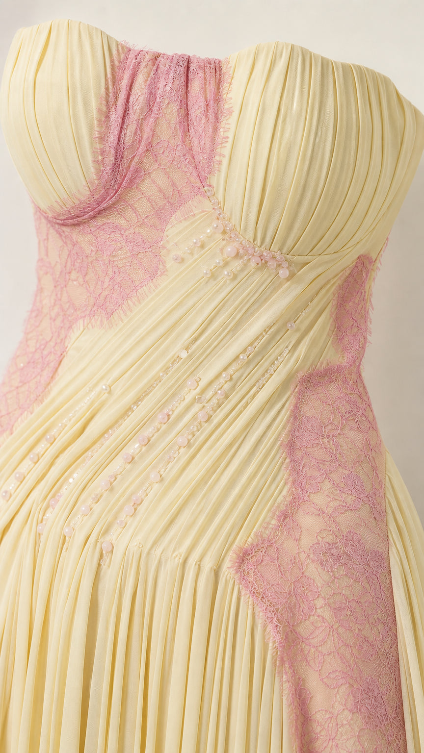 Close-up detail of pleated bodice and lace trim on evening gown