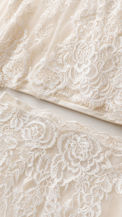 Close-up detail of white floral lace fabric and scalloped hem