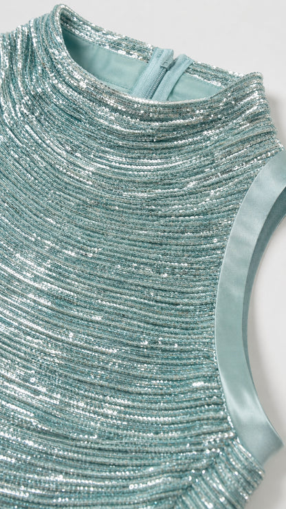 Close-up detail of mint green textured sequin fabric and high mock neckline with back zipper