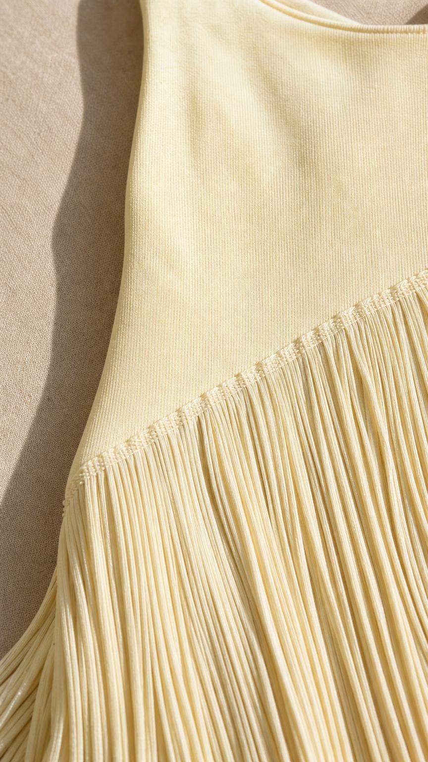 Close up detail of yellow ribbed knit and fringe hem