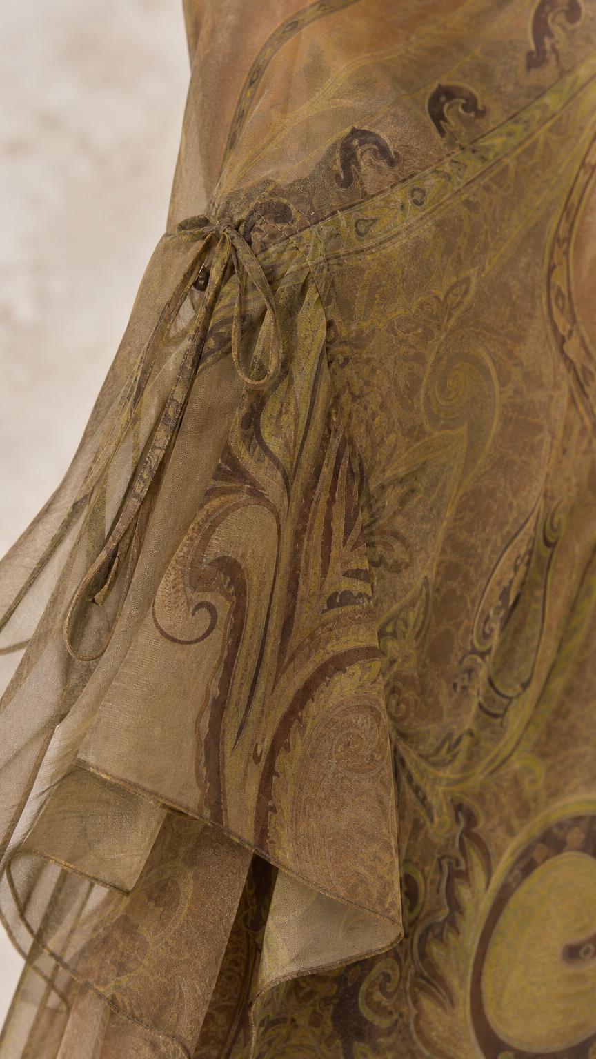 Close-up of olive paisley dress draped hem and tie detail