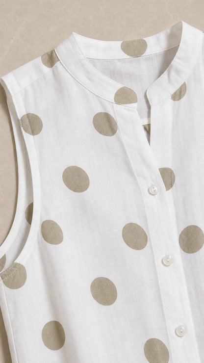 Close up of mandarin collar and button details on white polka dot top