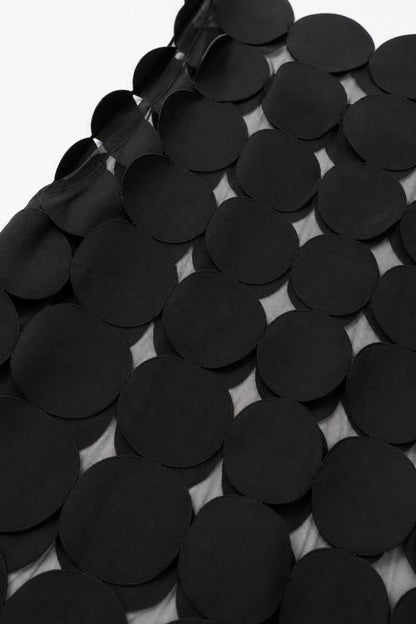 Close-up detail of smooth black circular fabric appliques