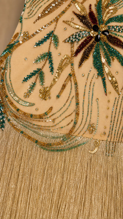 Close-up detail of green and gold sequin palm embroidery and fringe texture
