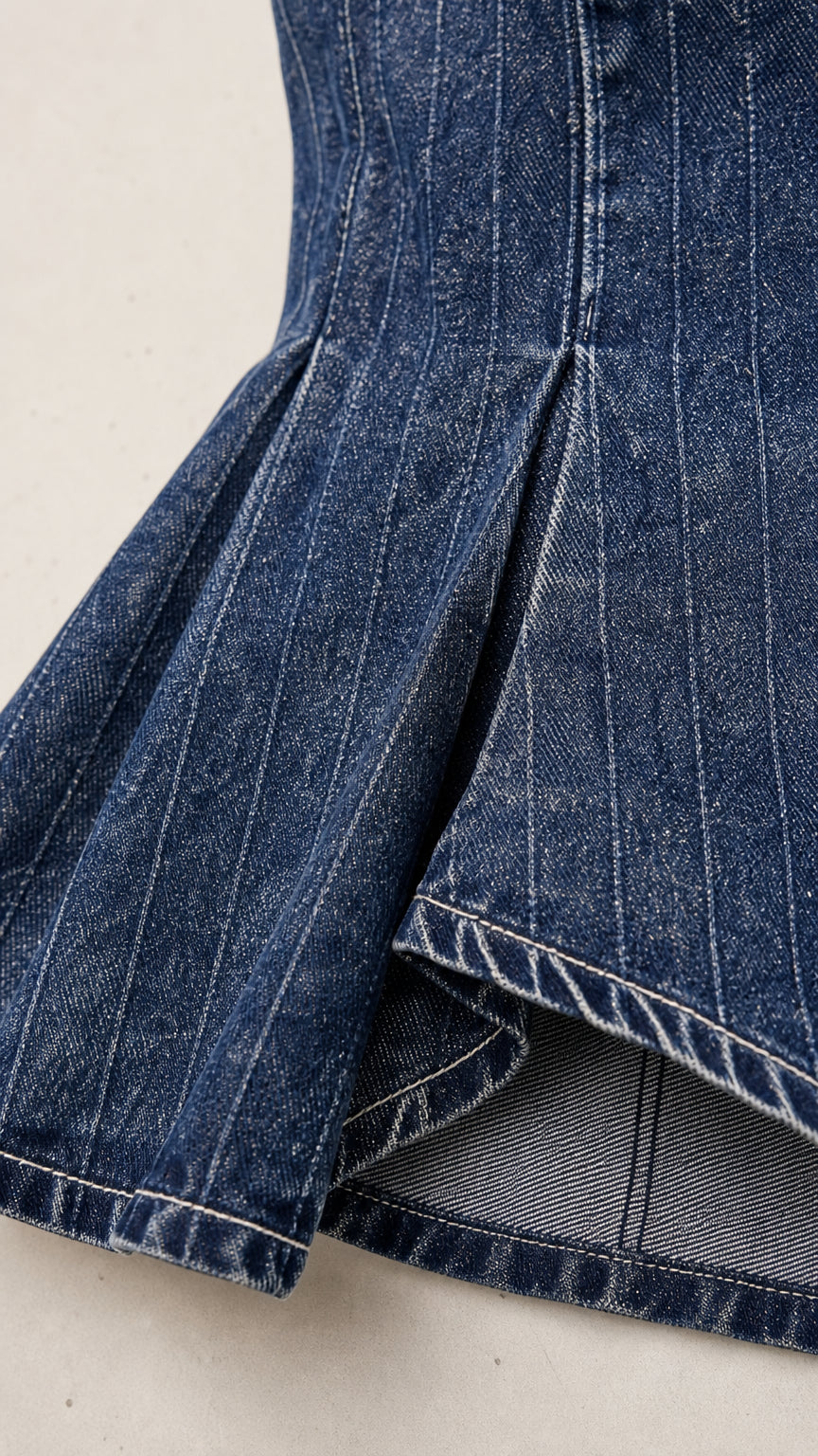 Close-up detail of the hem and vertical seam construction on denim pants