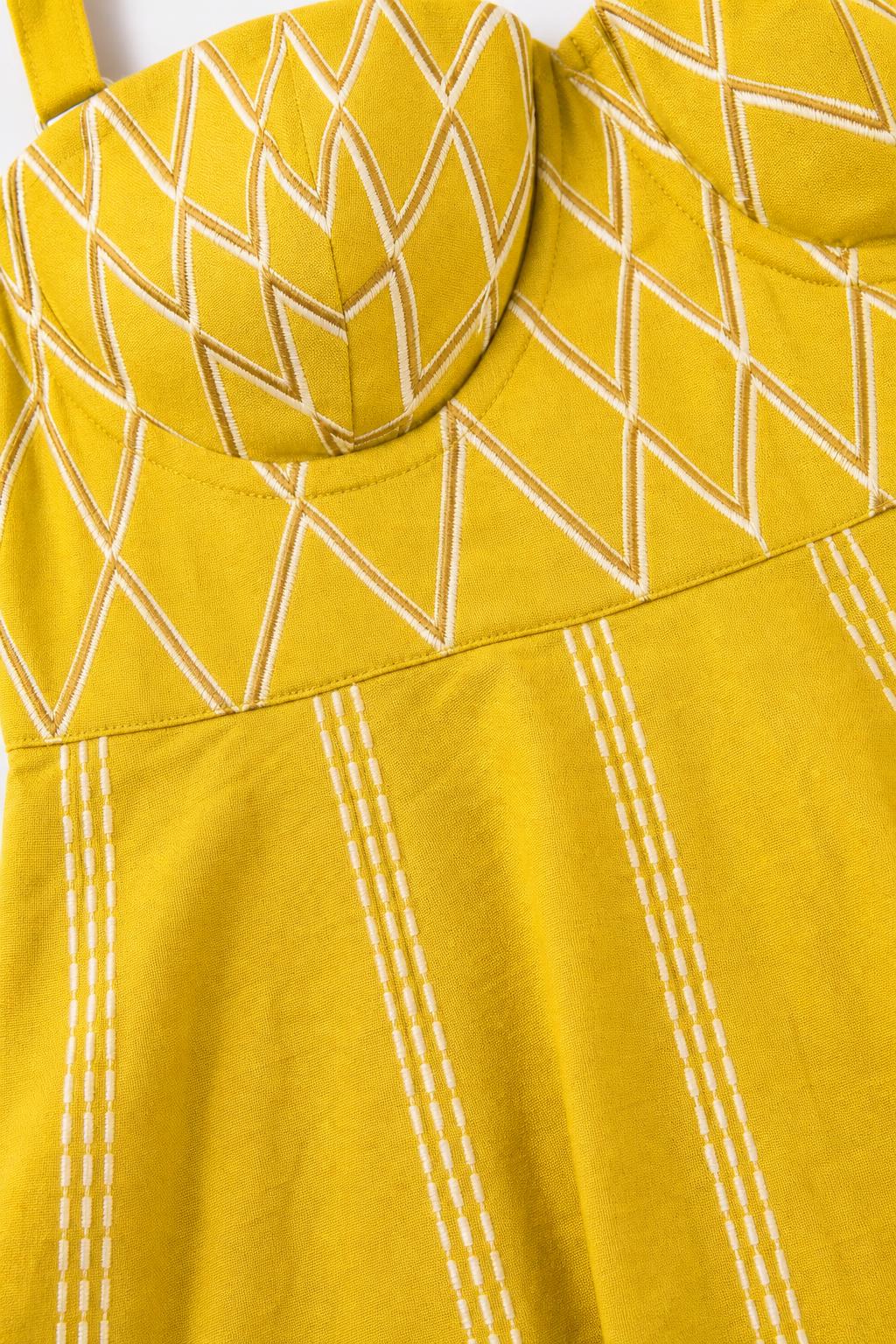 Close-up detail of Yellow dress embroidered bodice and fabric