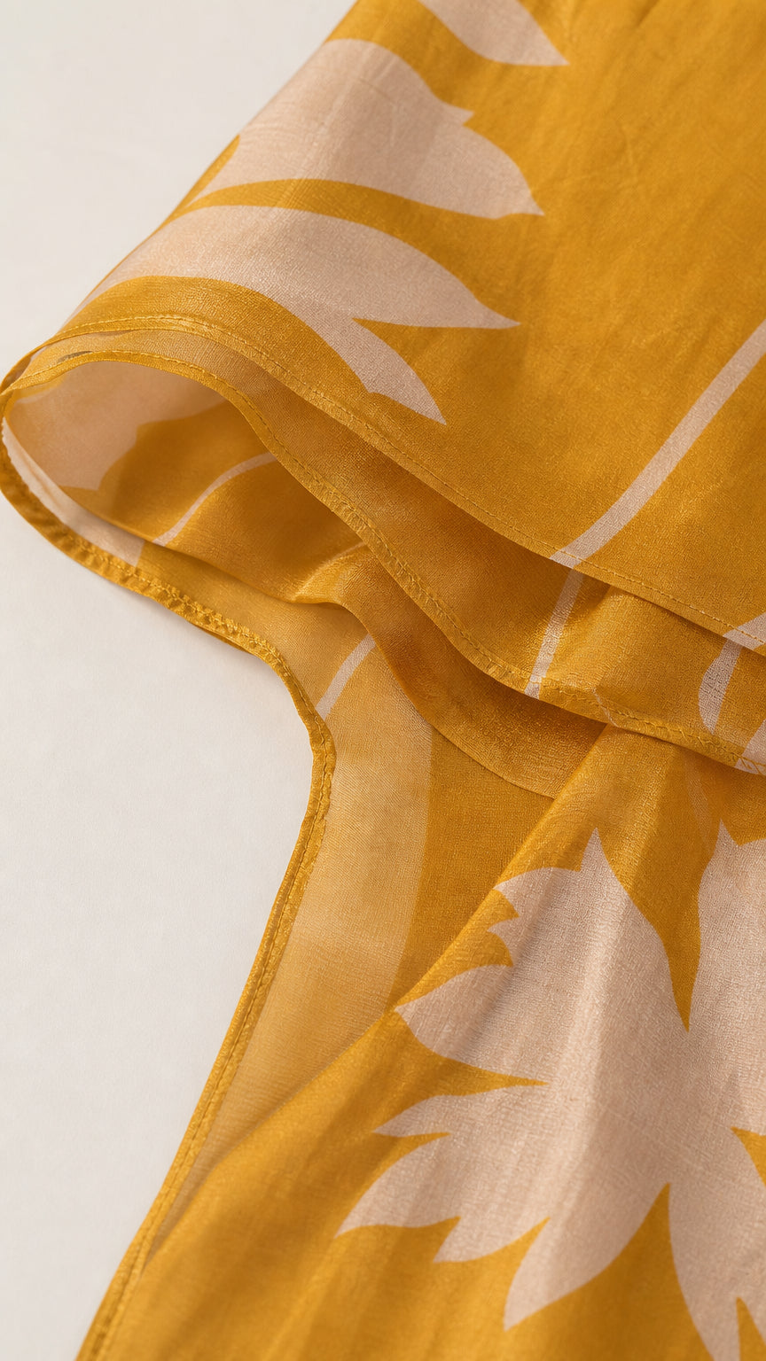 Close-up detail of mustard yellow fabric texture and floral pattern