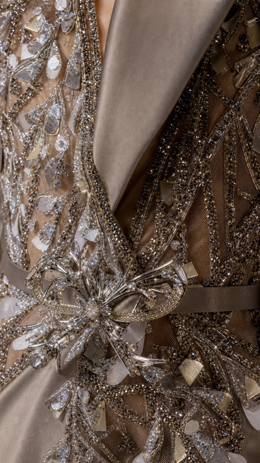 Close up of intricate beadwork, crystals, and satin lapel details on the gown
