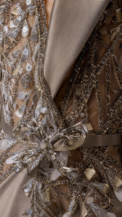 Close up of intricate beadwork, crystals, and satin lapel details on the gown