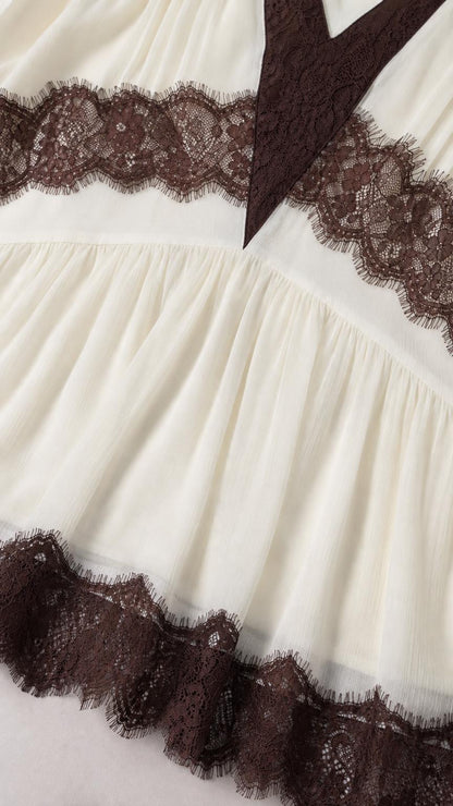 Close-up detail of lace inset and hemline on white dress