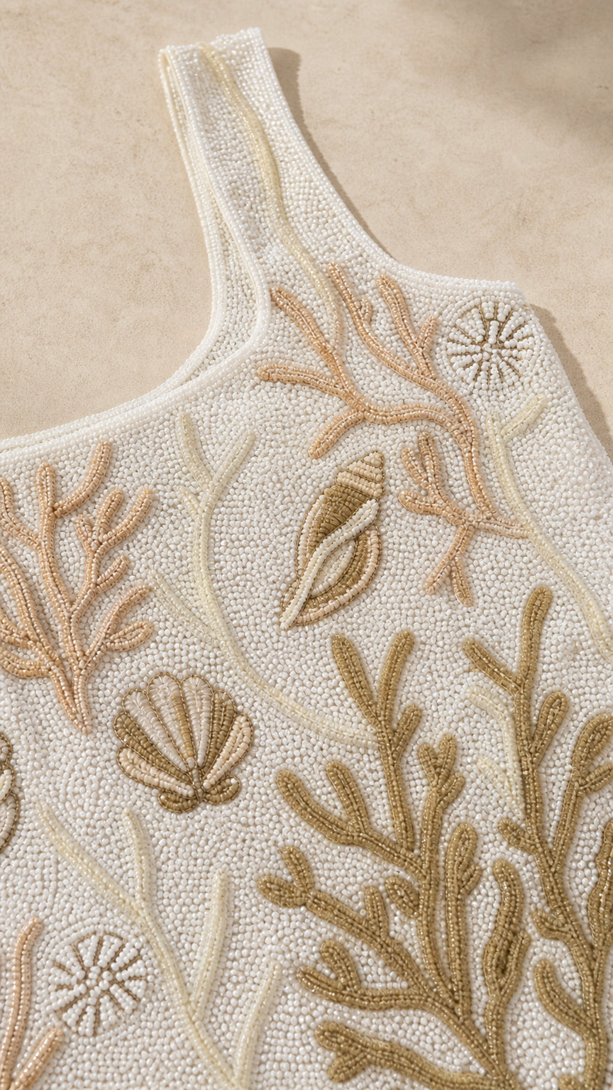Close-up detail shot of intricate beadwork showing coral and shell patterns