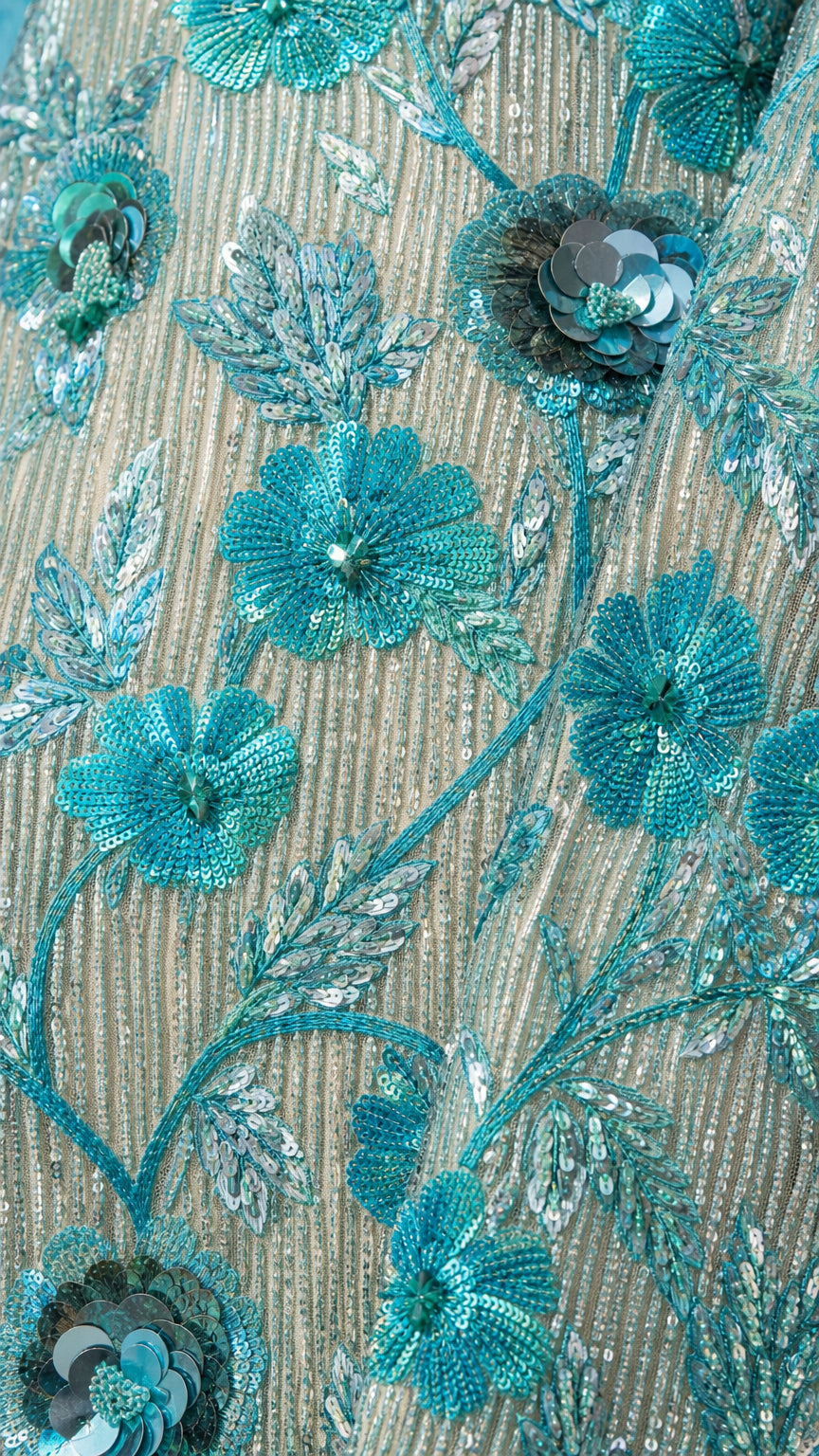 Close-up detail of aqua sequin embroidery and dimensional 3D beaded floral appliques