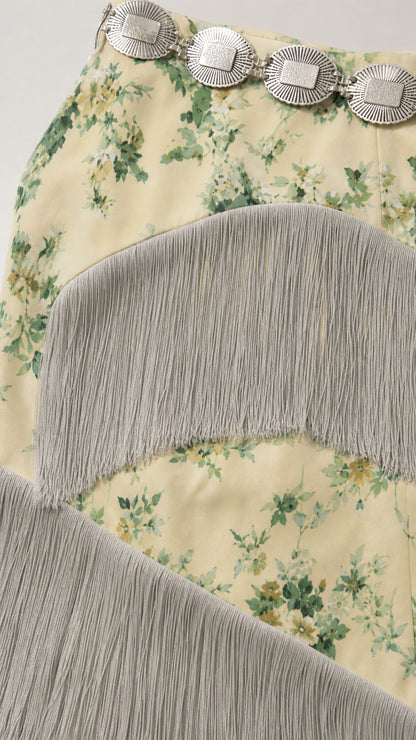 Close up detail of floral print fabric with cascading fringe trims and belt detail