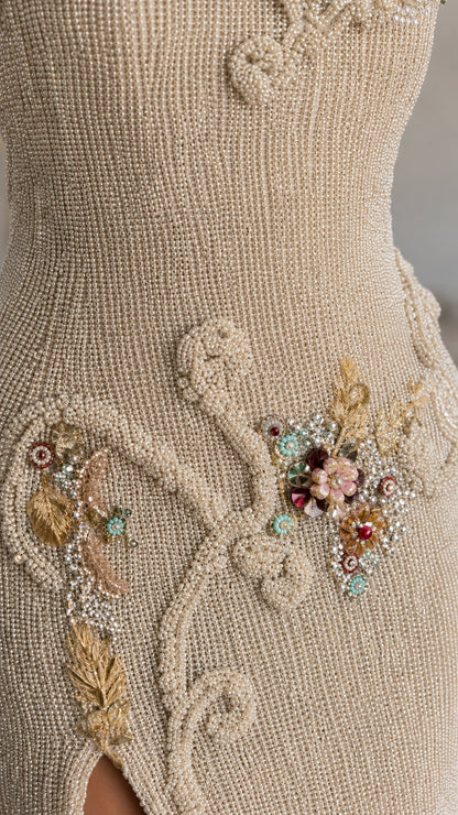 Close-up detail of floral beadwork and metallic fabric texture