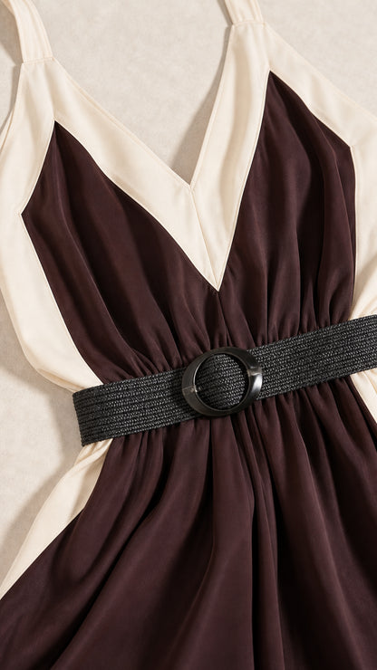 Close-up detail of V-neckline with cream contrast border and woven buckle belt