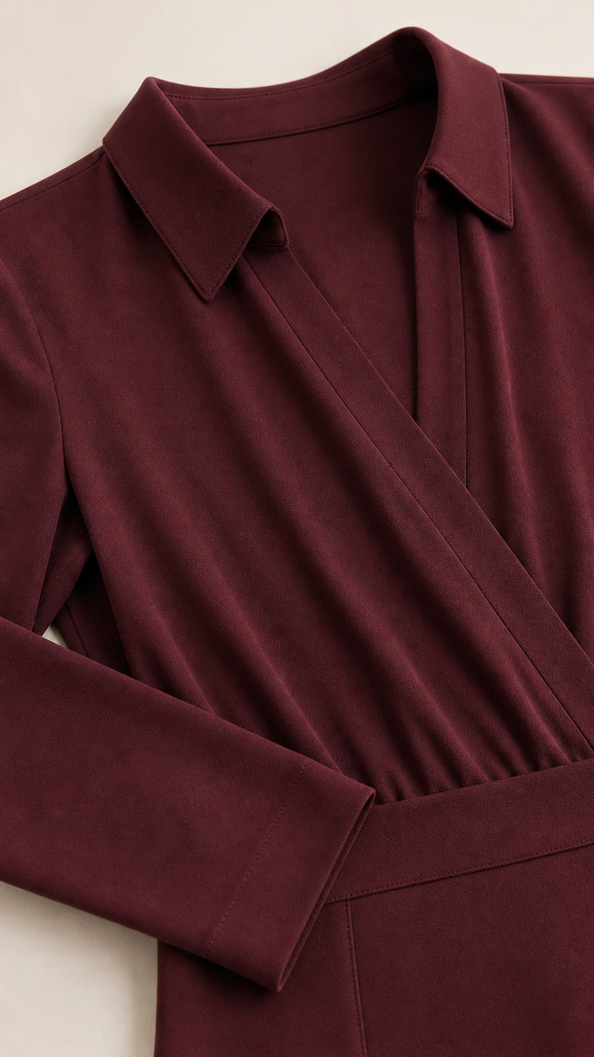 Close-up detail of burgundy dress lapel collar, wrap neckline, and cuff