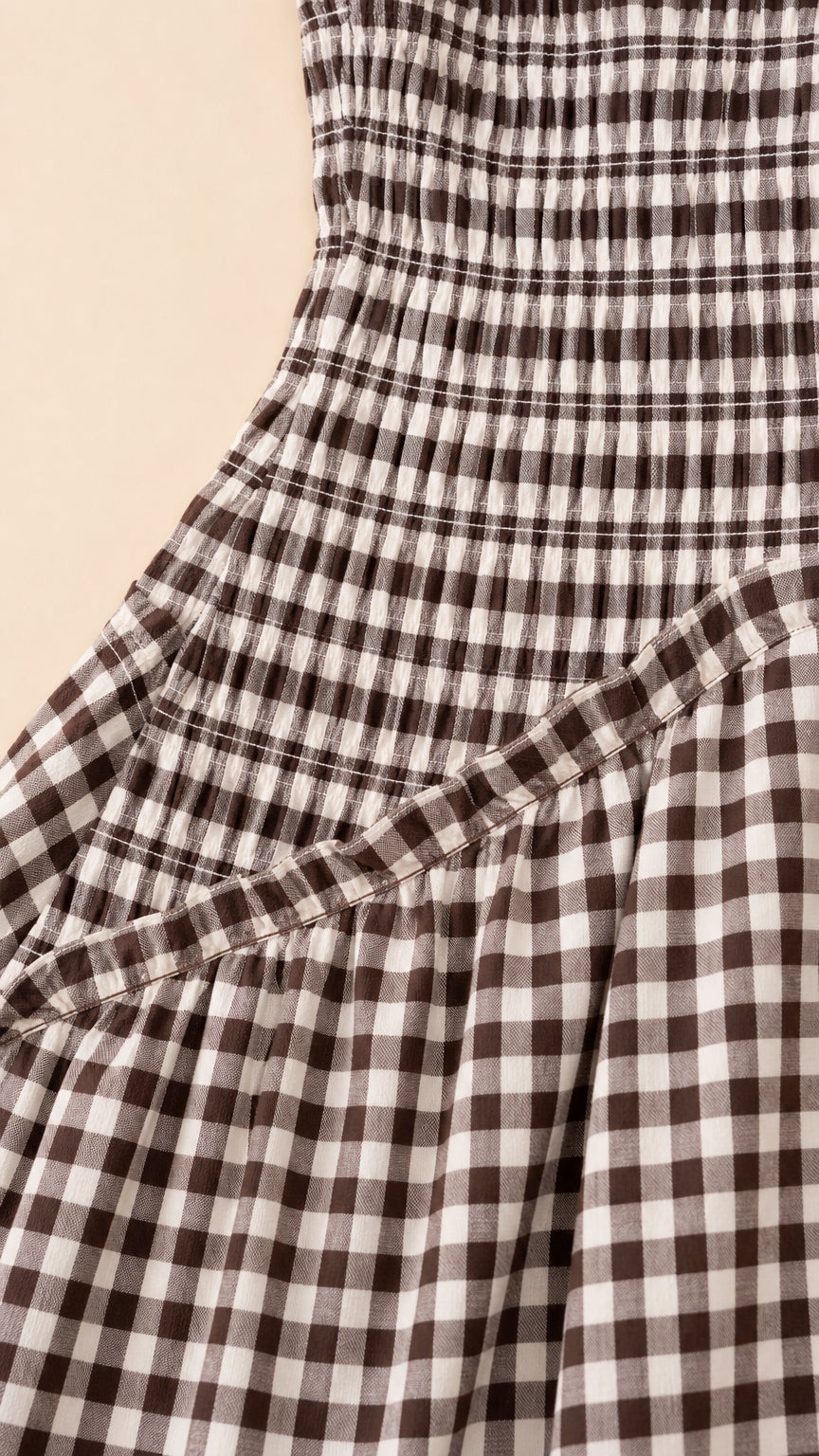 Close-up detail of smocked bodice and diagonal seam on gingham dress