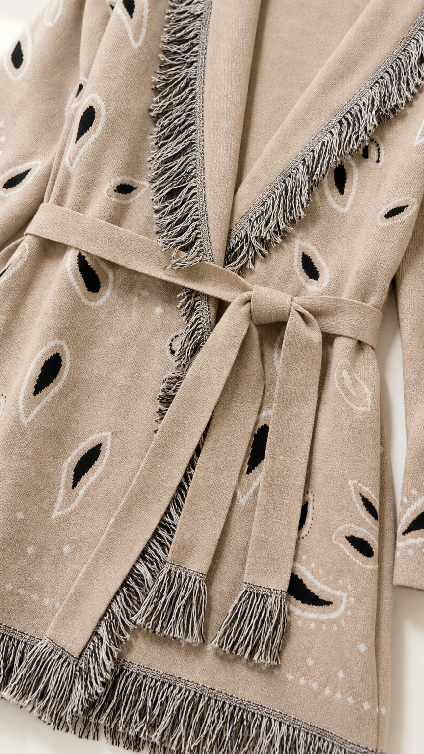 Close-up detail of fringe trim and belt on khaki cardigan