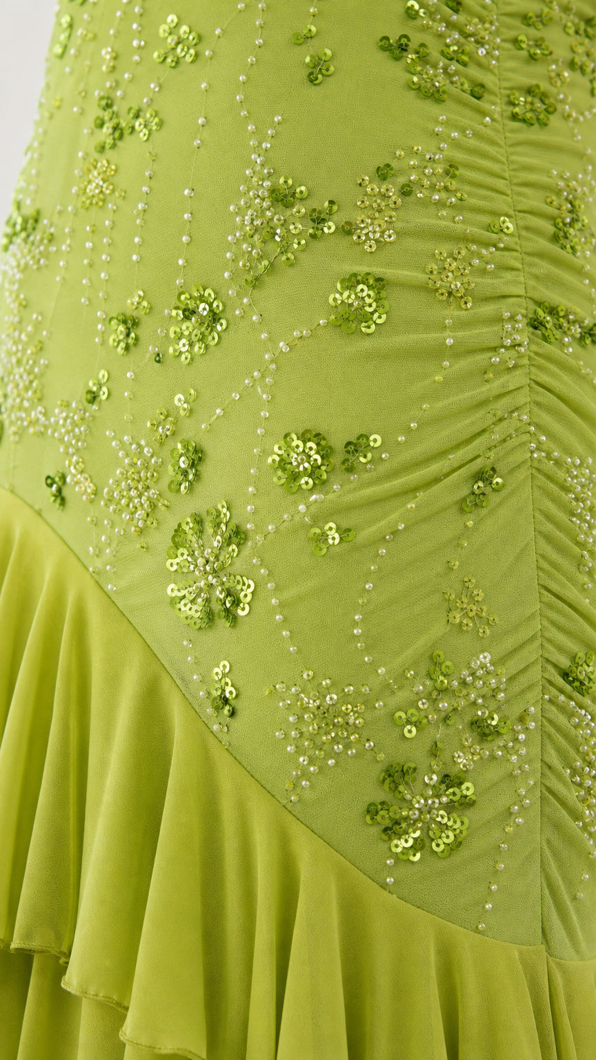 Close-up of sequin embroidery and ruffled hem on lime green dress