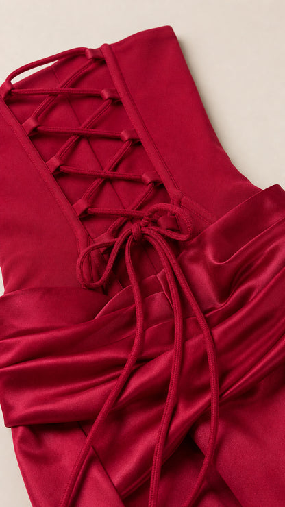 Close-up of burgundy satin-like fabric, ruching, and lace-up back detail