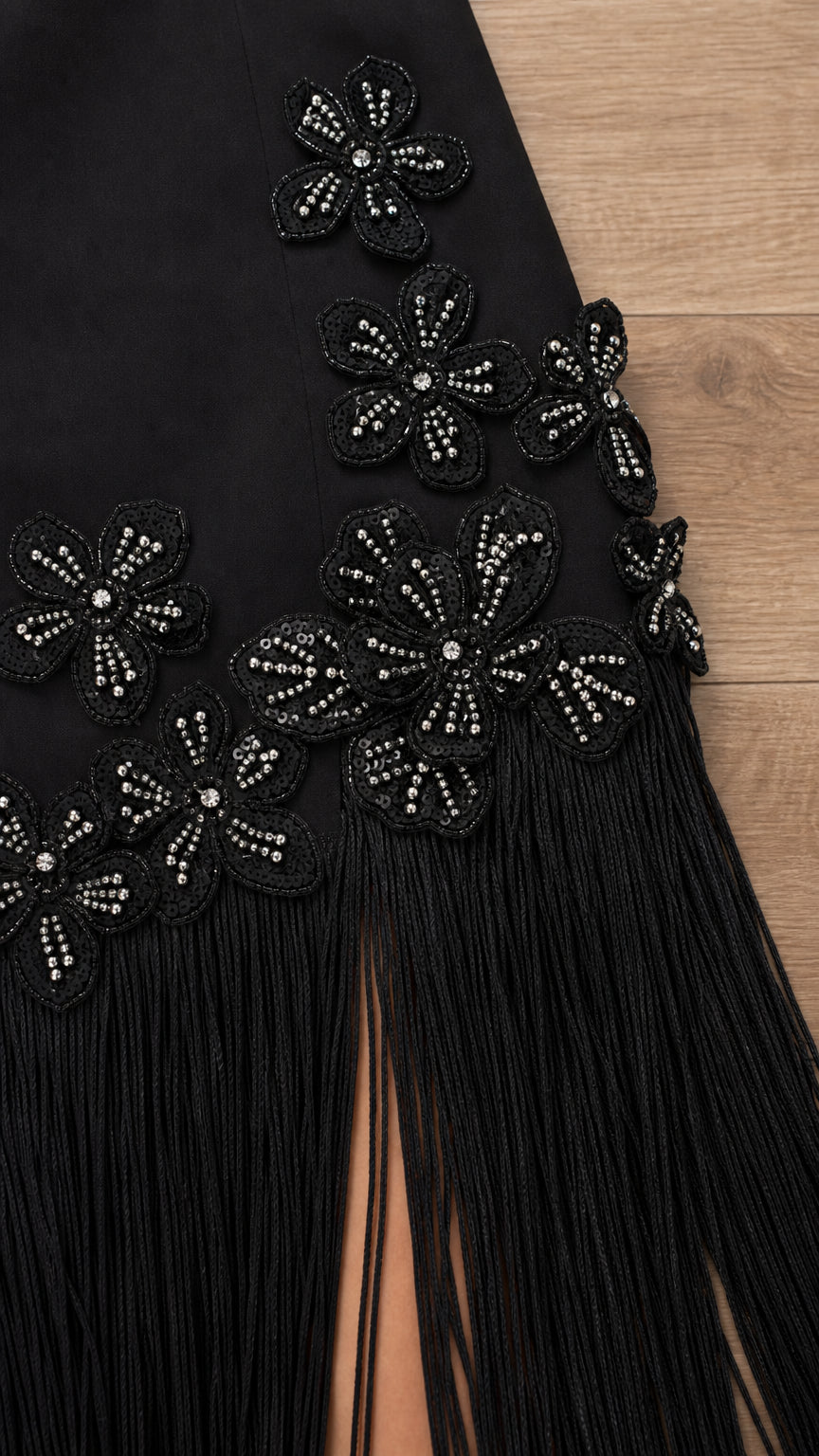 Close-up detail of beaded floral appliqués on black dress