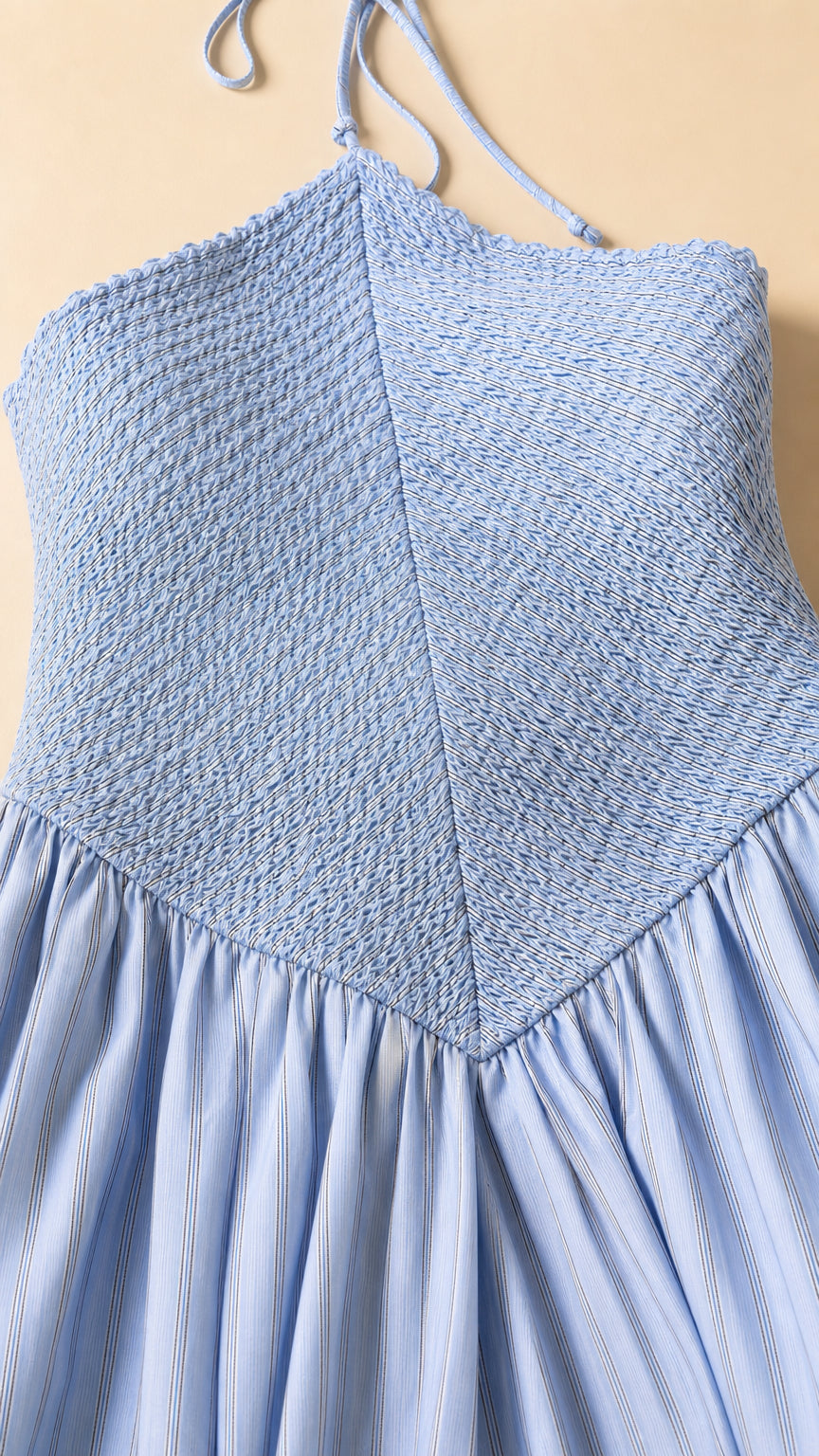 Close-up detail of light blue smocked bodice and gathered drop waist