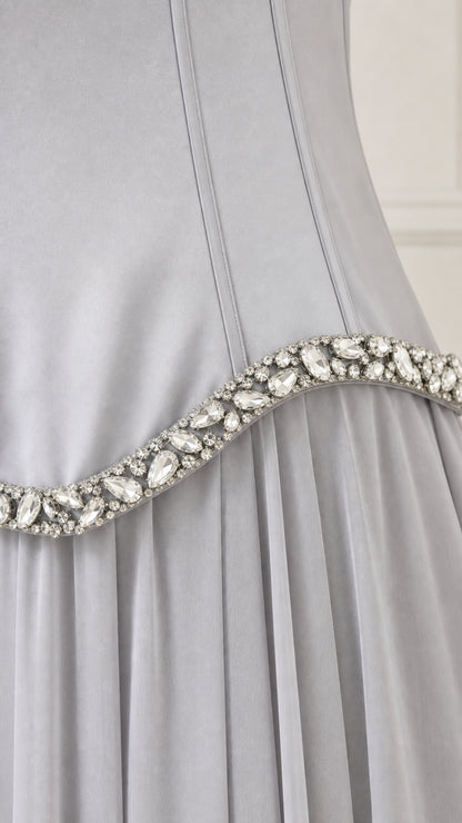 Close-up detail of rhinestone waist embellishments and pleated chiffon fabric