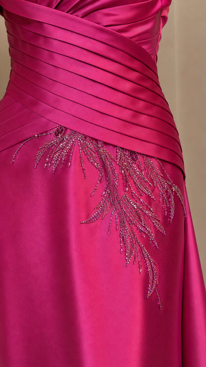 Close-up of pleated bodice and bead embroidery on fuchsia gown