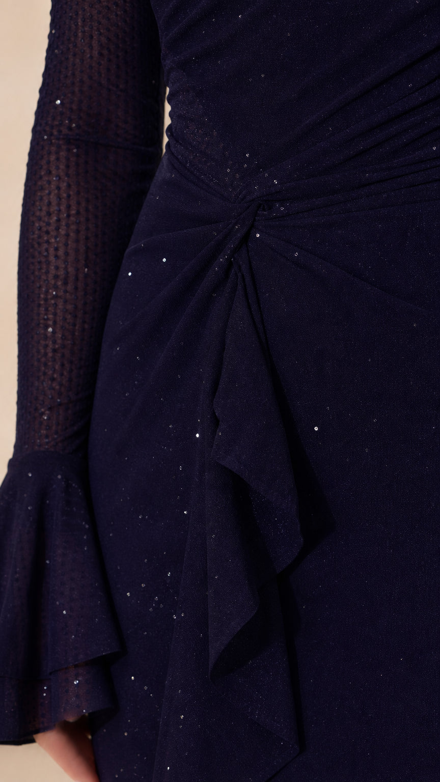 Close-up detail of fabric texture, bell sleeve, and ruffle on navy gown