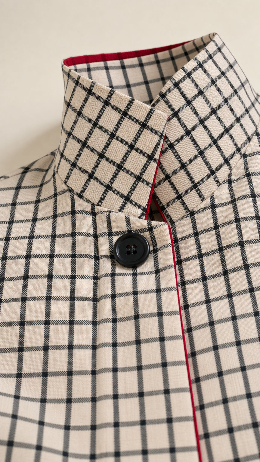 Close-up detail of high stand collar with button and piping on Cream grid dress