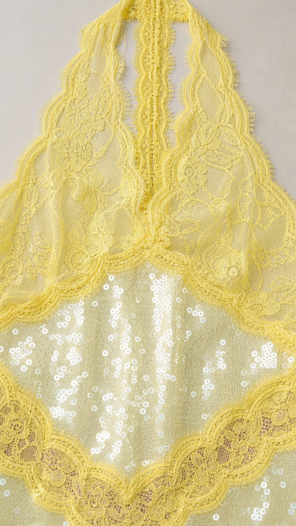 Close-up detail of yellow floral lace halter bodice and sequin embroidery