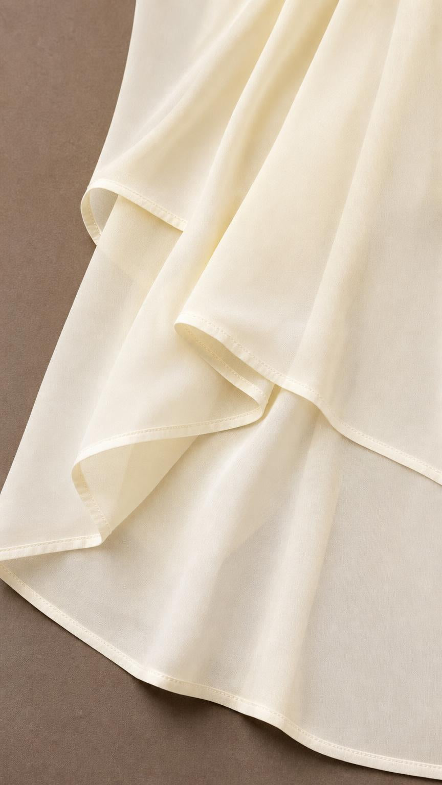 Close-up of multi-layer chiffon hem detail in ivory