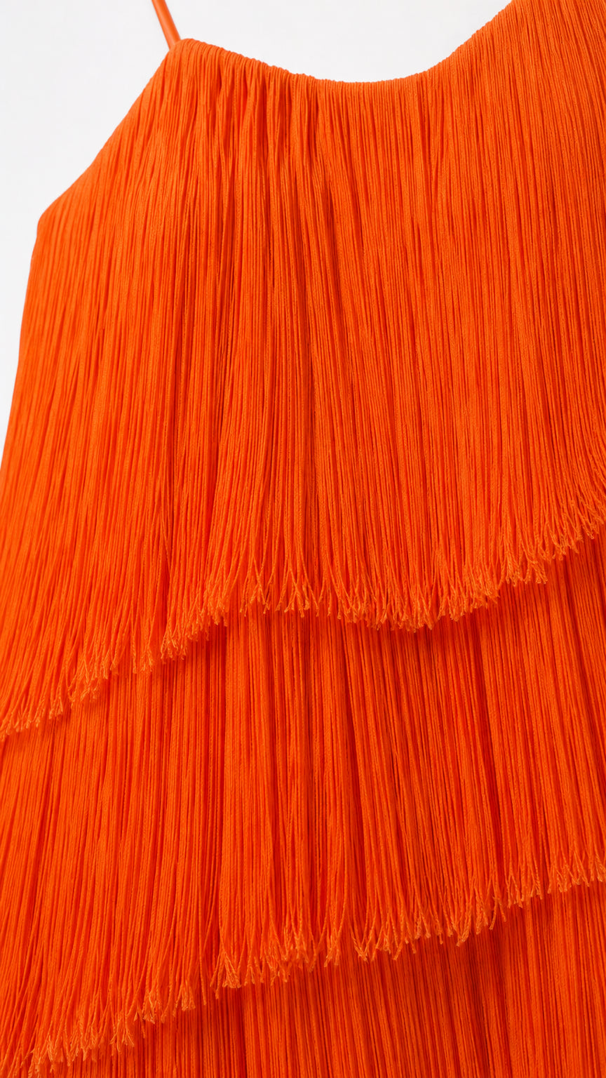 Close-up detail of tiered orange tassel fringe fabric texture and straps