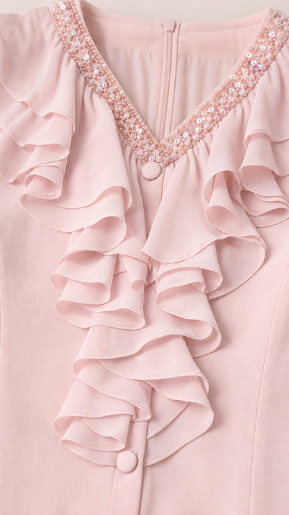 Close-up detail of embellished V-neckline and cascading ruffles in pink