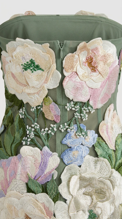 Close-up detail of 3D floral appliques and beadwork on sage green dress