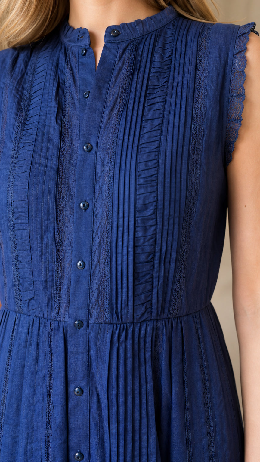 Close-up of pleated bodice and button front on blue dress