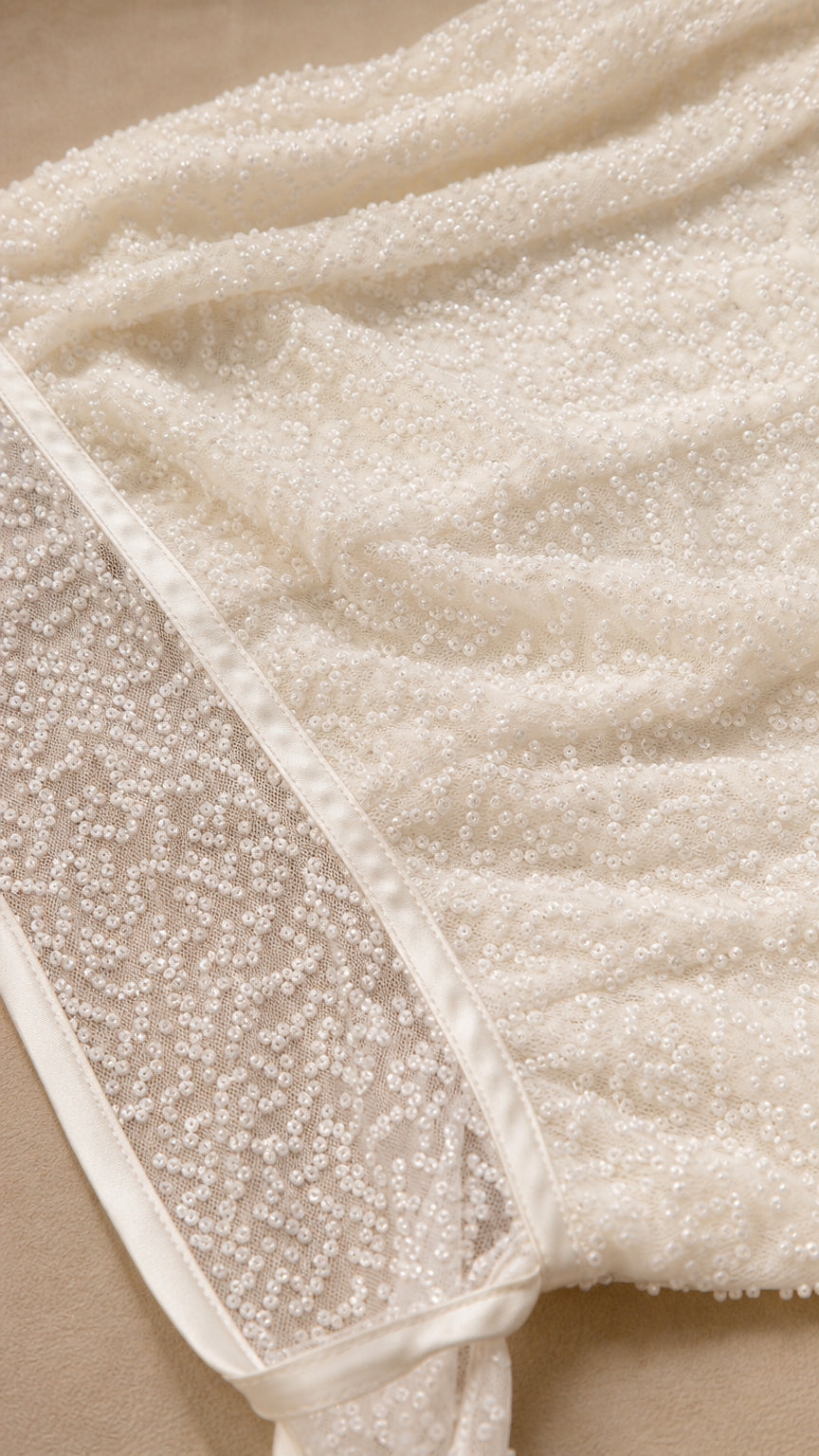 Close-up detail of textured white sequin fabric and trim