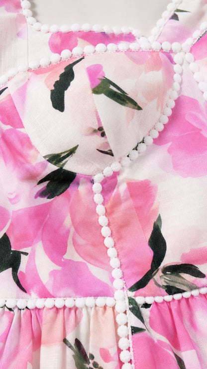 Close-up detail of bodice and pom-pom trim on floral dress