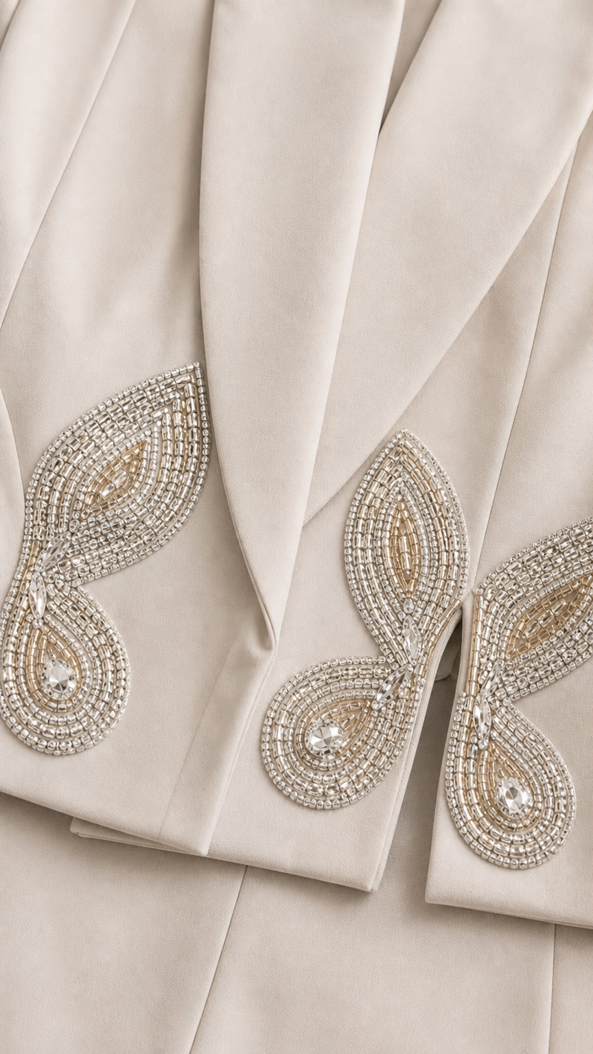 Close up detail of sparkling rhinestone and bead applique on blazer lapel hem