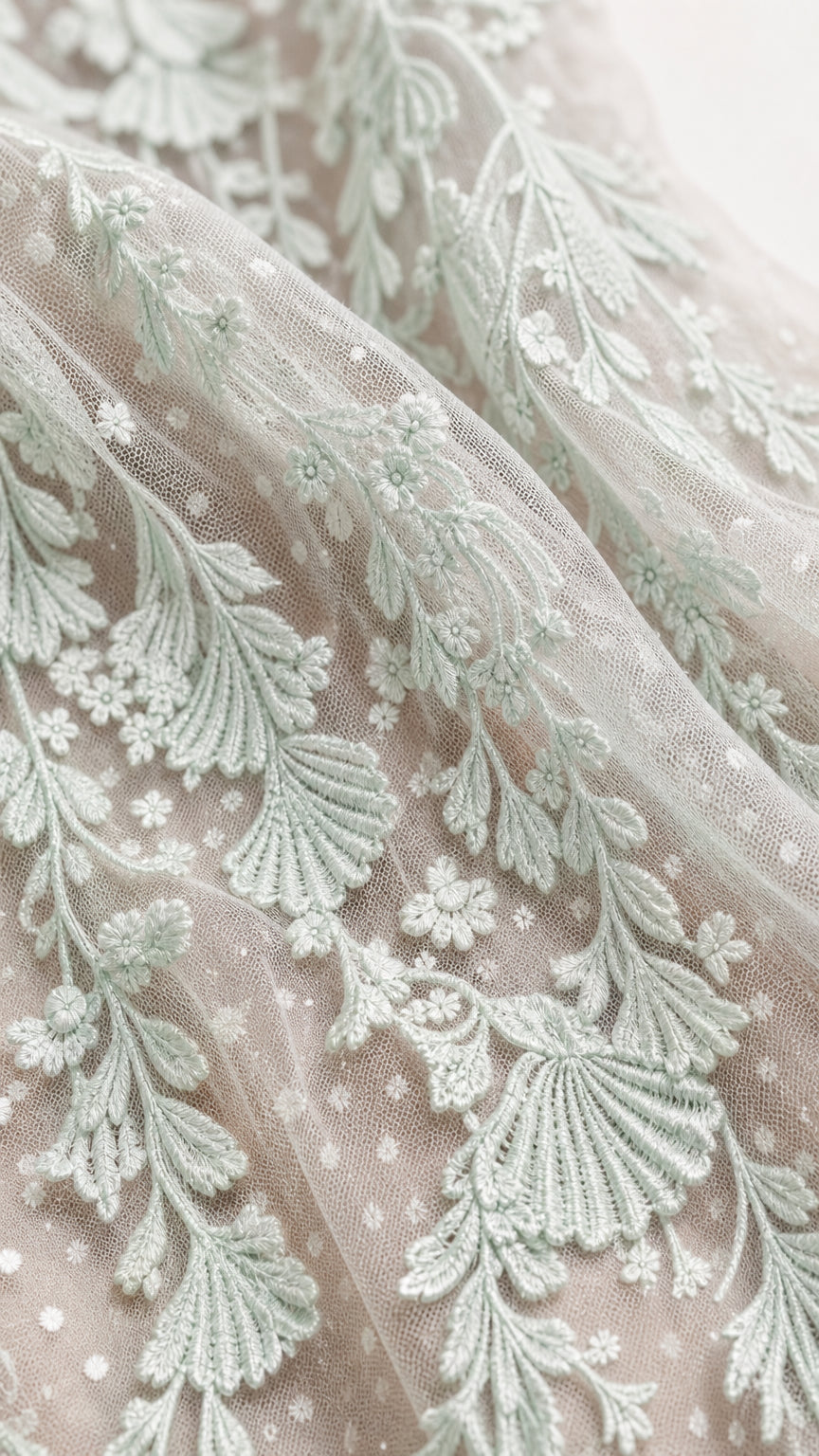 Close-up detail of mint floral embroidery on sheer mesh fabric