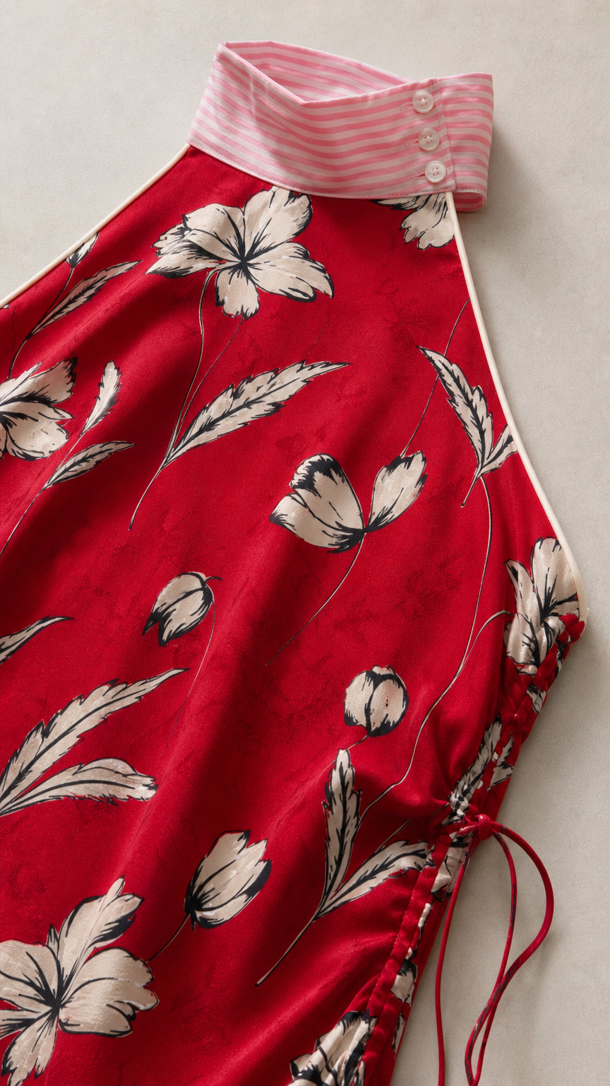 Close-up of contrast striped collar and fabric detail on red dress
