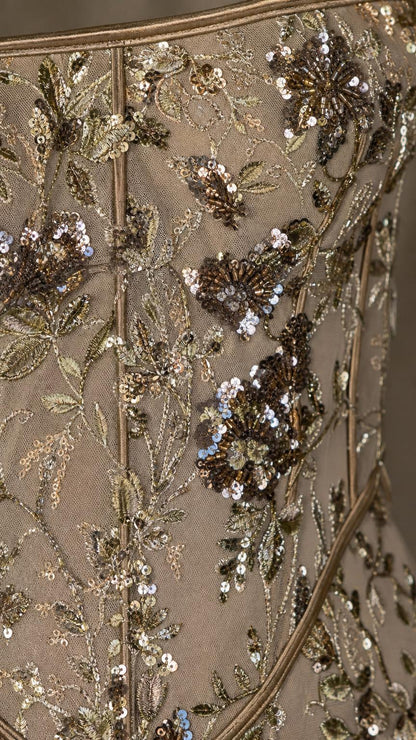 Close-up detail of sequin and bead floral embroidery on mesh fabric