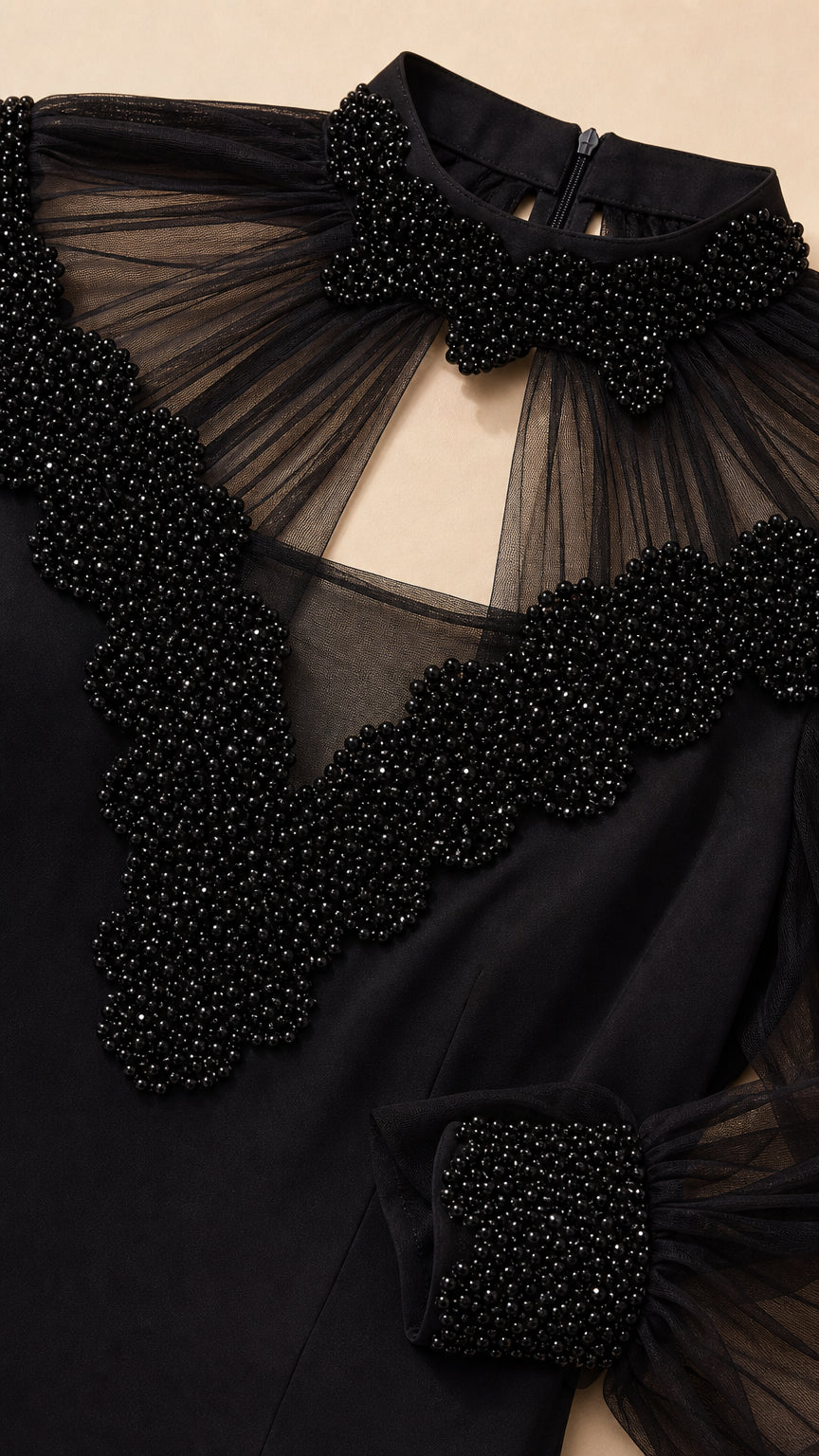 Close up of beaded neckline and mesh sleeves
