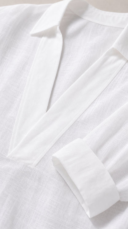 Close-up detail of white collar and cuffed sleeve