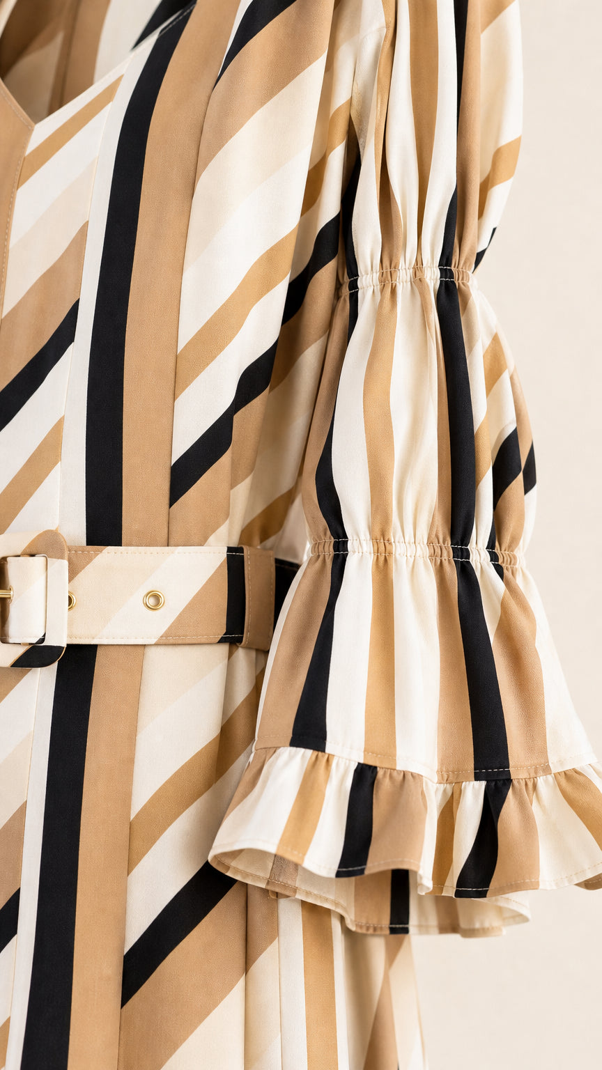 Close-up detail of belt and ruffled sleeve on striped midi dress