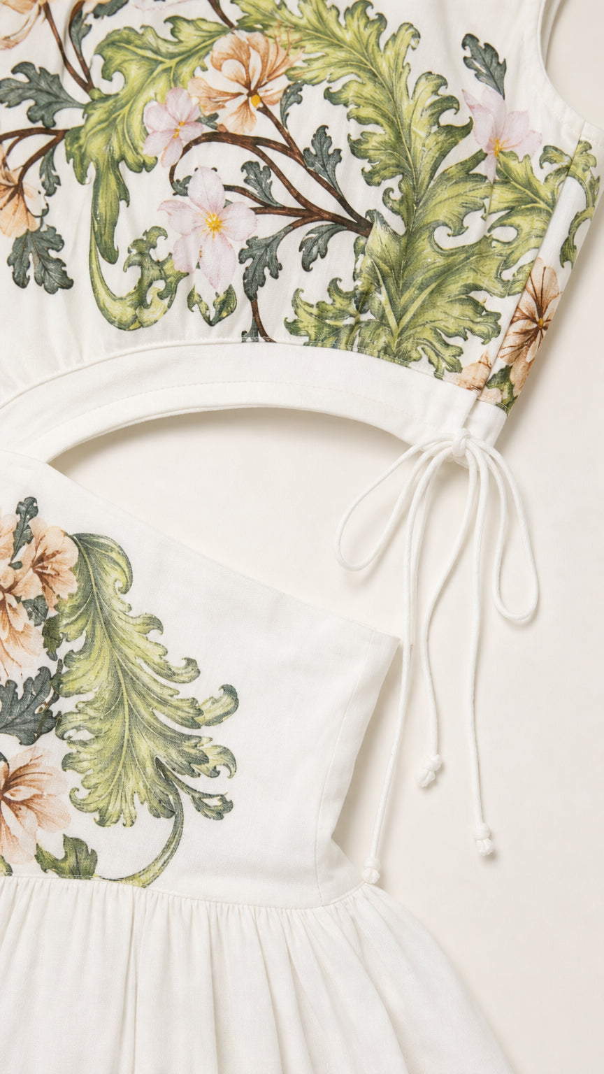 Close-up detail of white dress bodice, floral pattern, and side tie